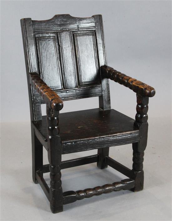 A 17th century oak wood seat elbow chair, with a panelled back
